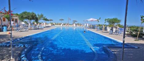 Piscine extérieure, parasols de plage, chaises longues