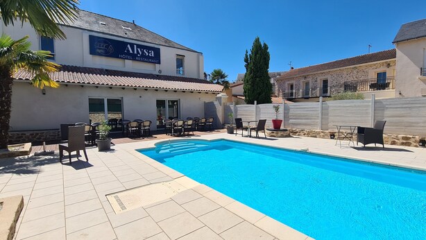 Ett hotell med en swimmingpool, utomhusservering och en skylt med texten ”ALYSA HOTEL – RESTAURANG”.