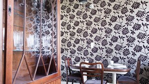 A dining area with a wooden cabinet, a table, and chairs.