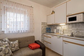 A compact kitchenette with a microwave, coffee maker, and a small refrigerator.