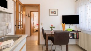 Una cocina moderna con microondas, fregadero y comedor con sillas y una mesa.