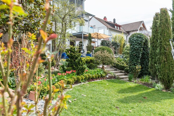 Il s’agit d’une propriété résidentielle dotée d’un jardin bien entretenu, d’un escalier menant à l’entrée et d’un espace extérieur couvert.