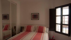 A bedroom with a bed, a wardrobe, a window, and a framed picture on the wall. - Center, luminous apt - 2 bathrooms (Sevilla)