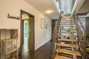 A staircase with wooden steps and metal railings, a wooden shelf unit, and a door labeled 'Lavendel.' - Cozy, Lovingly Furnished Holiday Apartment "Lavendel" with Covered Terrace & Balcony (Sipplingen am Bodensee)