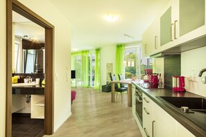 A modern kitchen with a dining area, a visible sink, and a coffee machine.