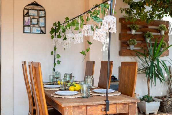 Mesa de madera con platos, vasos y limones, rodeada de sillas de madera.