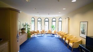 A conference room with a blue carpet, beige walls, and a row of yellow chairs. - Residenz Am Malerwinkel (Bad Sassendorf)