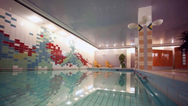 An indoor swimming pool with a tiled wall featuring a colorful mosaic design. - Residenz Am Malerwinkel (Bad Sassendorf)