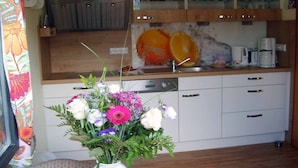 Una cocina con armarios de madera, un lavabo y una cafetera.
