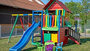 A playground with a slide, climbing structures, and a small building with a roof. - Pferdefreunde Loberhof (Weihenzell)