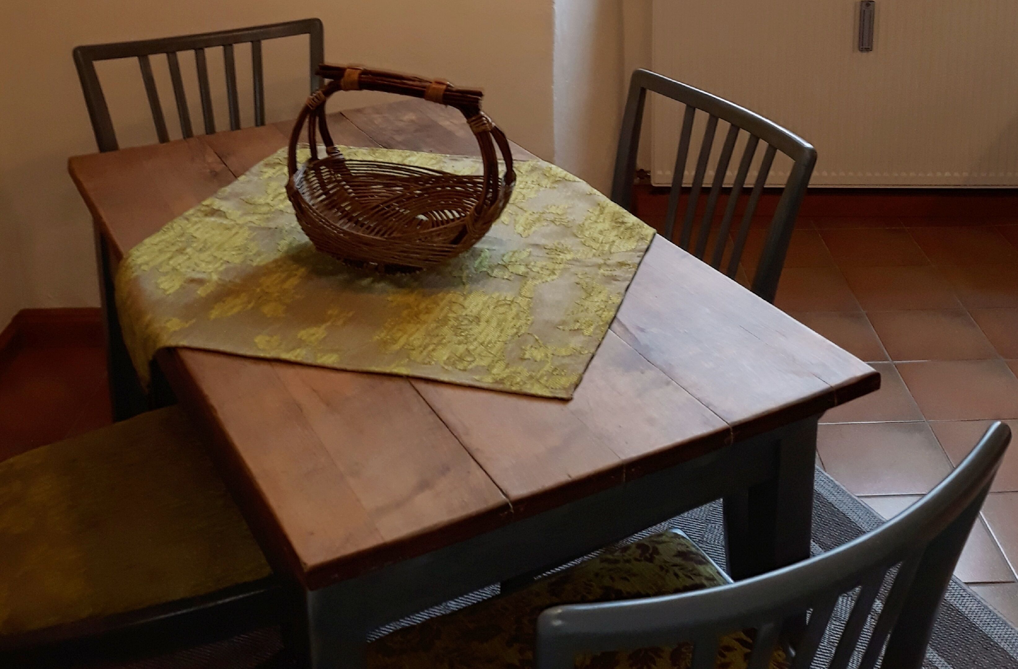 Une table à manger avec un panier tressé posé sur un chemin de table.