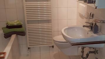 Appartement | Badkamer | Een aparte badkuip en douche, een haardroger, handdoeken