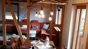 Ein Essbereich mit einem Holztisch, gedeckt für eine Mahlzeit, umgeben von Holzstühlen.