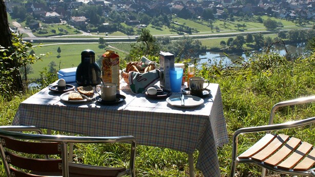 Ein Tisch im Freien mit Blick auf eine Stadt und einen Fluss.