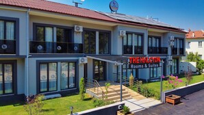 Un bâtiment moderne avec une enseigne indiquant « The Halcyon Rooms & Suites ».