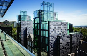 A modern building with a glass facade and a checkered pattern on the lower part.