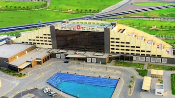 A large building with a prominent entrance and a swimming pool in front.