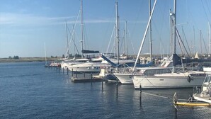 Een jachthaven met diverse zeilboten afgemeerd aan de steiger.