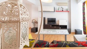 Una sala de estar moderna con un sofá blanco, una mesa de centro y un televisor.