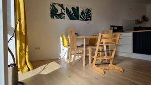Una cucina moderna con mobili in legno, un tavolo da pranzo e una tenda gialla.