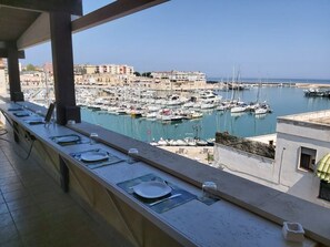 Ein Balkon mit Blick auf einen Yachthafen und Gebäude im Hintergrund.