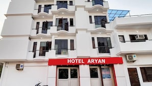 Un hotel de varios pisos con balcones y un letrero rojo que indica 'HOTEL ARYAN'.
