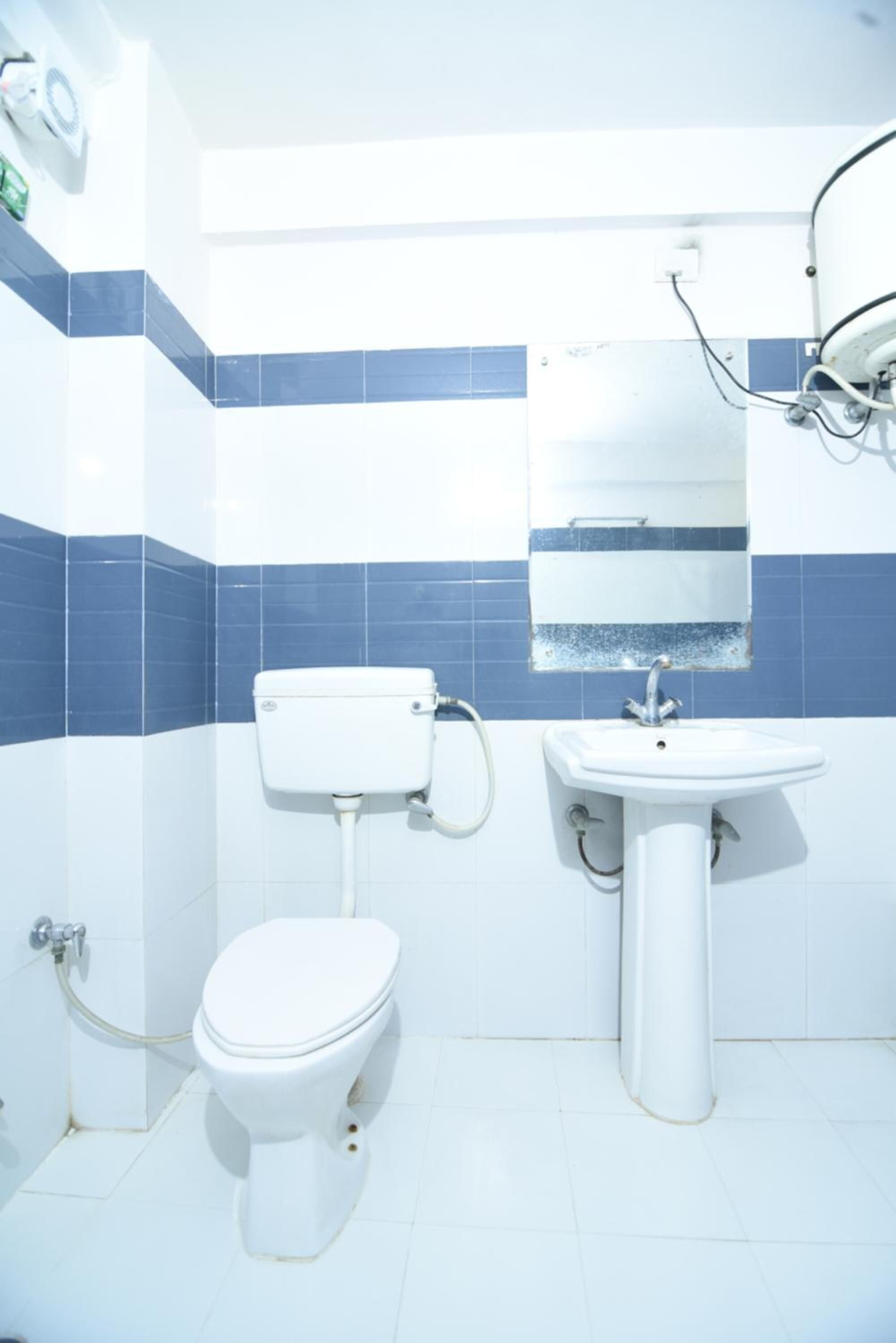 Un baño con inodoro, lavabo y espejo.