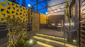 A modern outdoor area with geometric wall patterns, a small water feature, and ambient lighting. - Liiv Cobogó - Natal Ponta Negra (Natal)