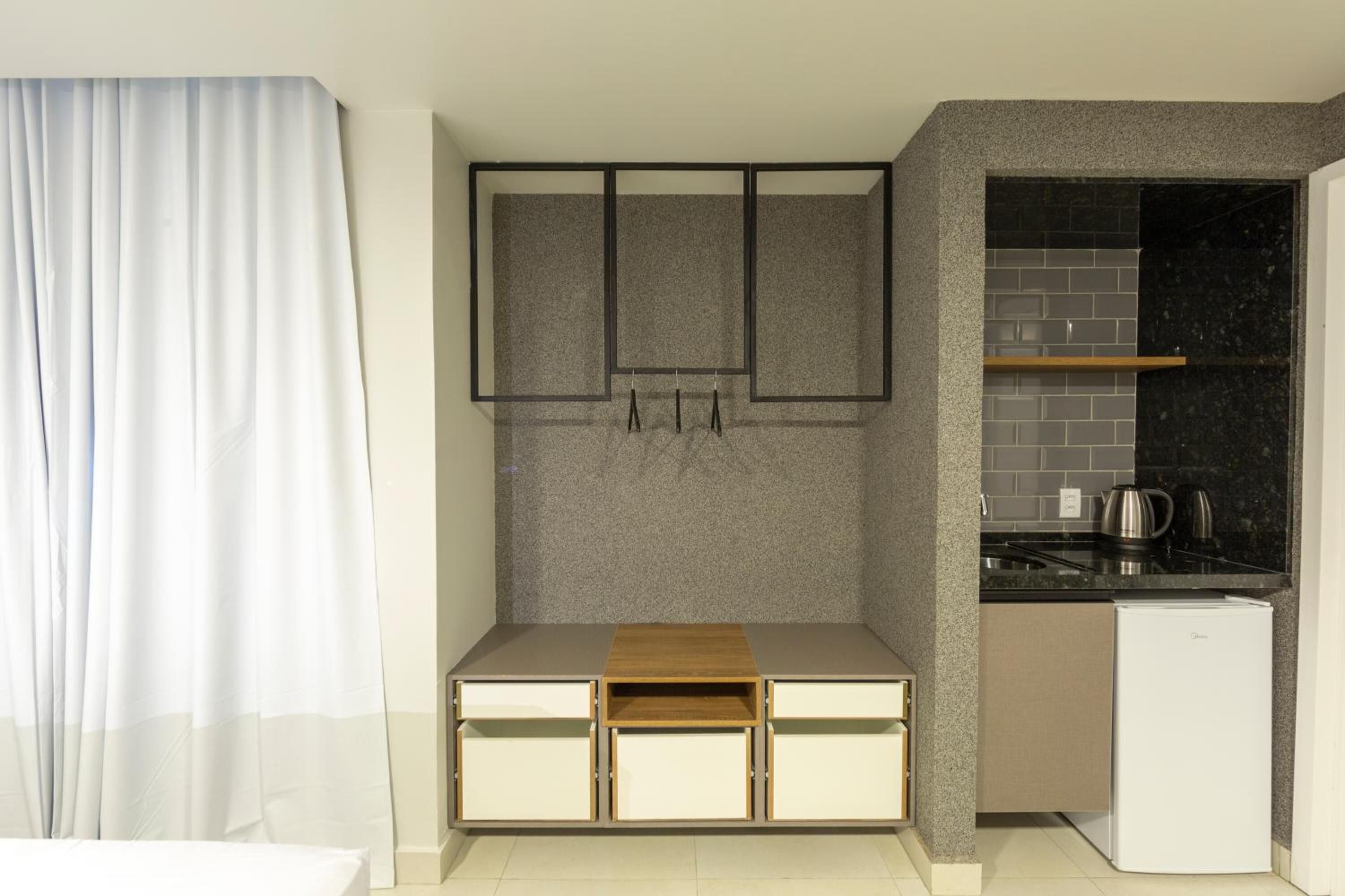 Una cocina compacta con refrigerador integrado, una encimera y un lavamanos pequeño.