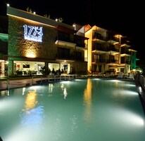 Un hotel con piscina, asientos al aire libre y un cartel que dice "1774".
