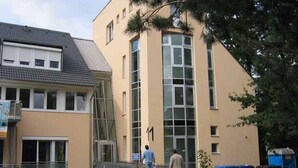 A building with a beige facade, a large window, and a number '1' sign. - Fewo im Josefinum (Bad Sassendorf)