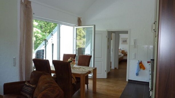 A spacious living area with a dining table, two brown leather sofas, and a wooden floor. - Fewo im Josefinum (Bad Sassendorf)