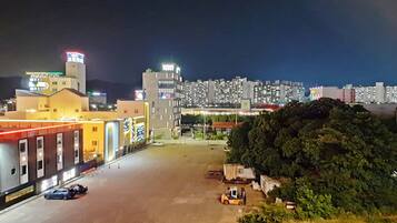 A nighttime view of a parking lot with buildings in the background.