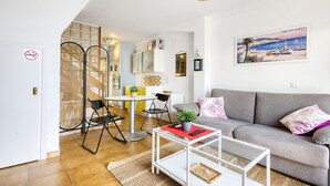A modern living room with a grey sofa, a glass coffee table, and a dining area with a round table and chairs. - MALLORCA 8 Canyelles Roses (Rosas / Roses)