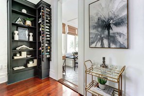 Une pièce avec une bibliothèque en bois sombre, une table vitrée à présentoir encadrée d’or et un grand tableau abstrait.