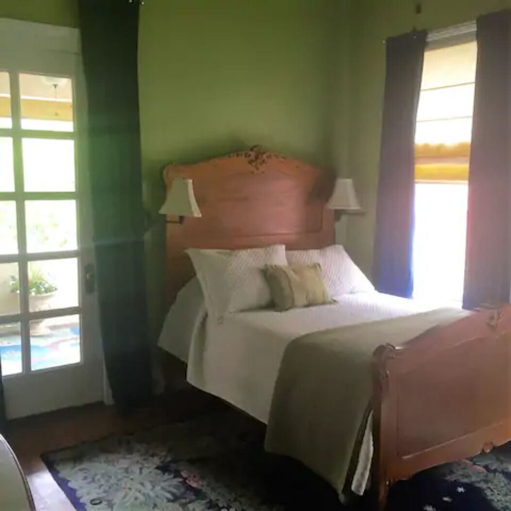 A bedroom with a wooden bed, white bedding, and two bedside lamps.