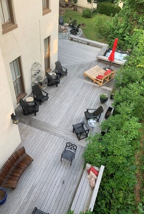 Eine Terrasse mit Gartenmöbeln, einem Whirlpool und einer Gartenanlage.
