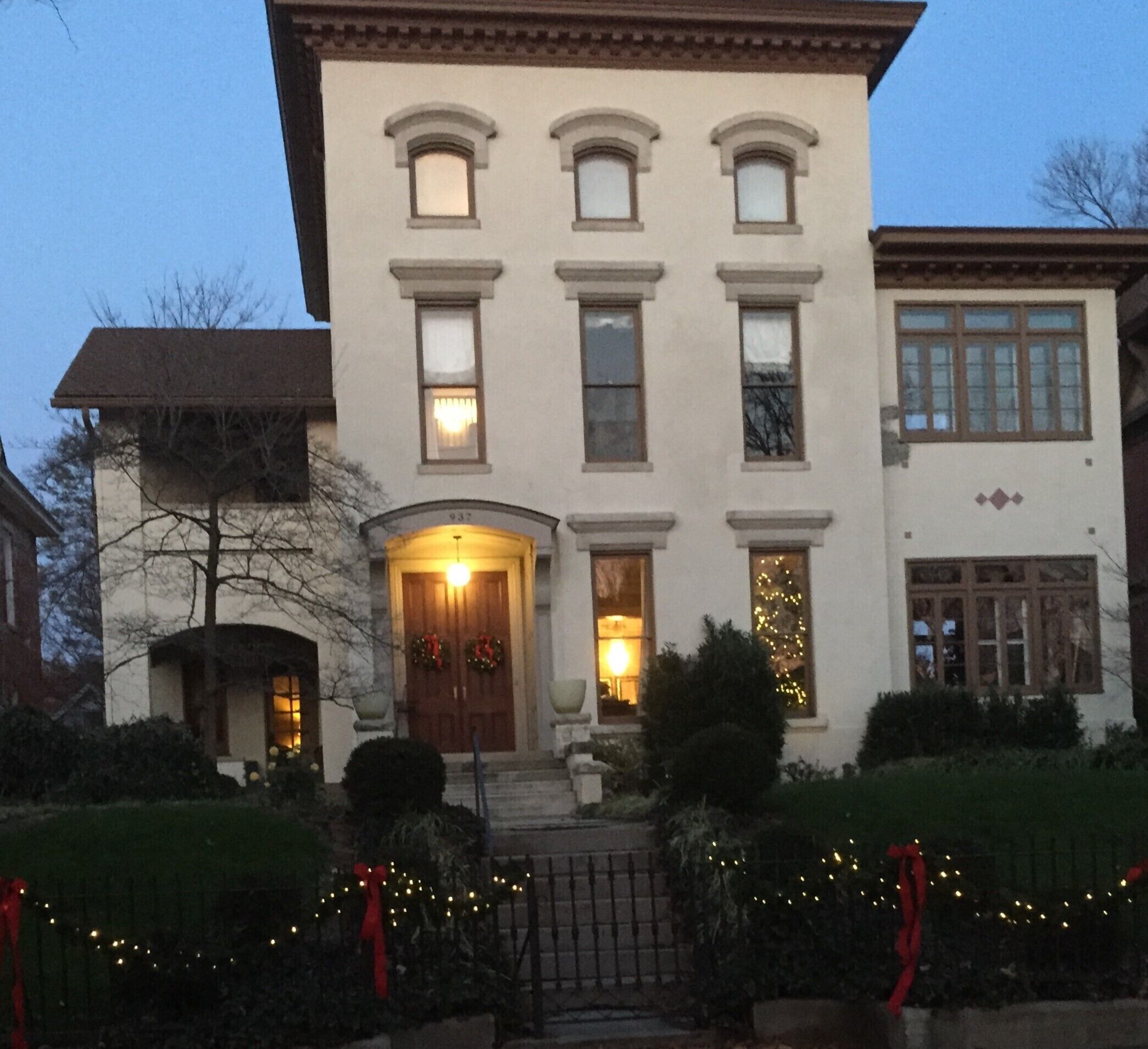 A two-story building with a central entrance, multiple windows, and a front porch.