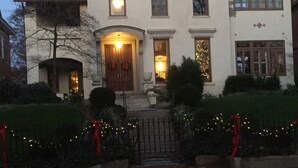 A two-story building with a central entrance, multiple windows, and a front porch. - Historic Mansion-Modern Amenities, Sauna, Fire Pit, Hot Tub, Deck, Walk to Dine (Louisville)