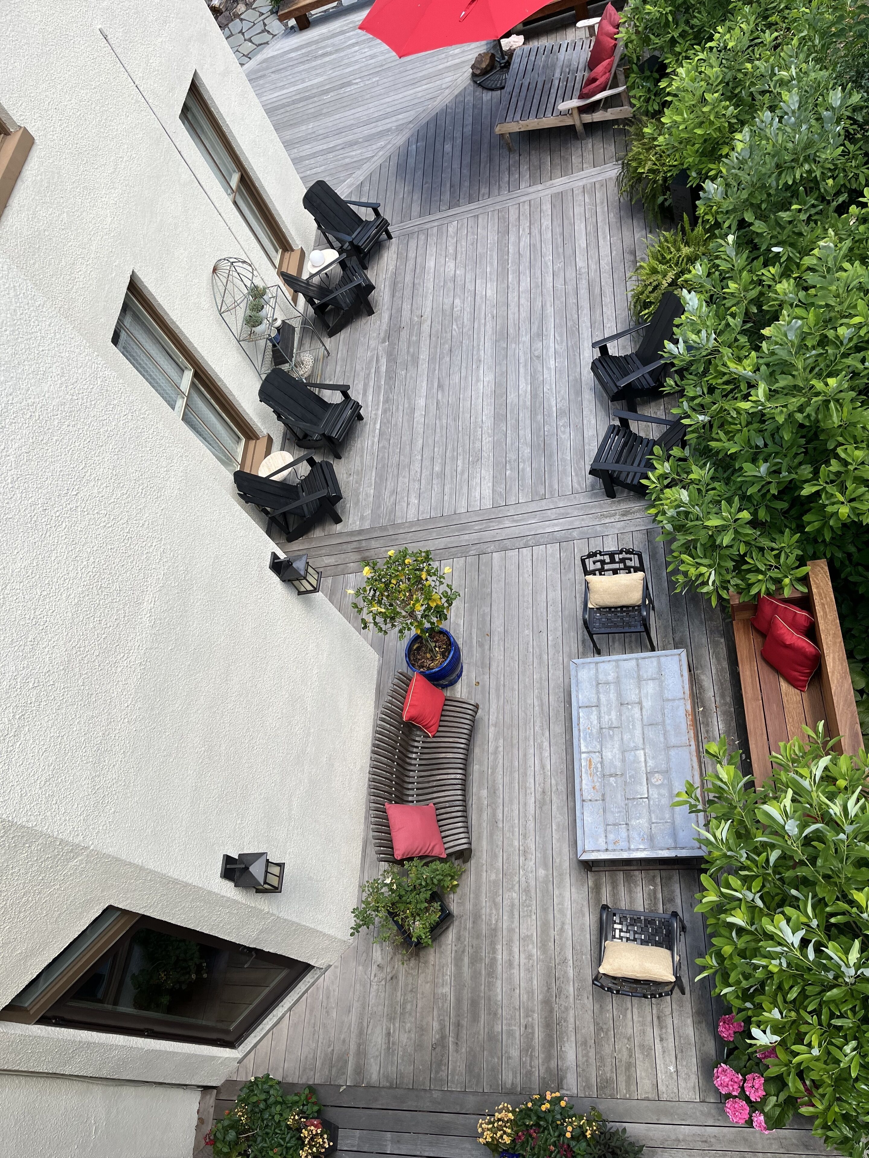 En takterrass med flera sittområden, inklusive solstolar och ett litet bord.