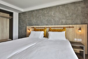 Un dormitorio moderno con una cama grande, cabecera de madera y dos lámparas de noche.
