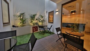 A hotel patio with outdoor seating, artificial grass, and potted plants. - Ivy Hotel - Adults Only (St. Julian's)