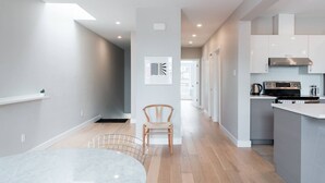 Une cuisine moderne dotée d’un îlot central, d’appareils électroménagers intégrés et d’un design minimaliste.