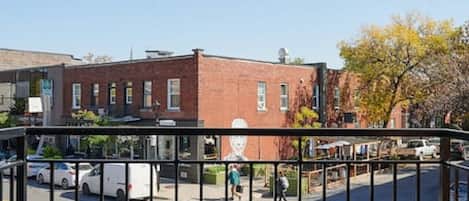 A gated entrance to a building with a clear view of the street and parked cars.