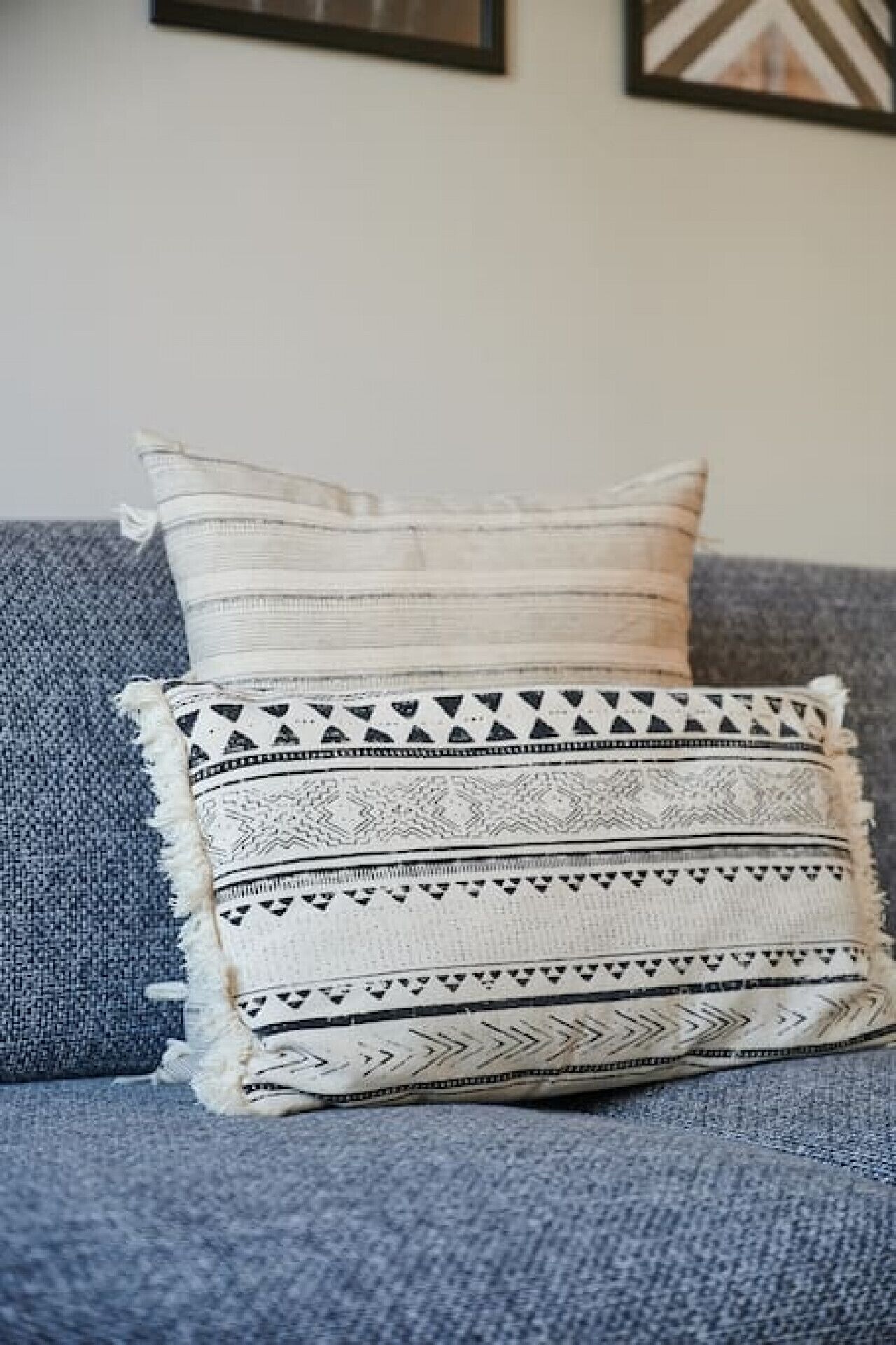 Un sofá azul con dos almohadones decorativos.