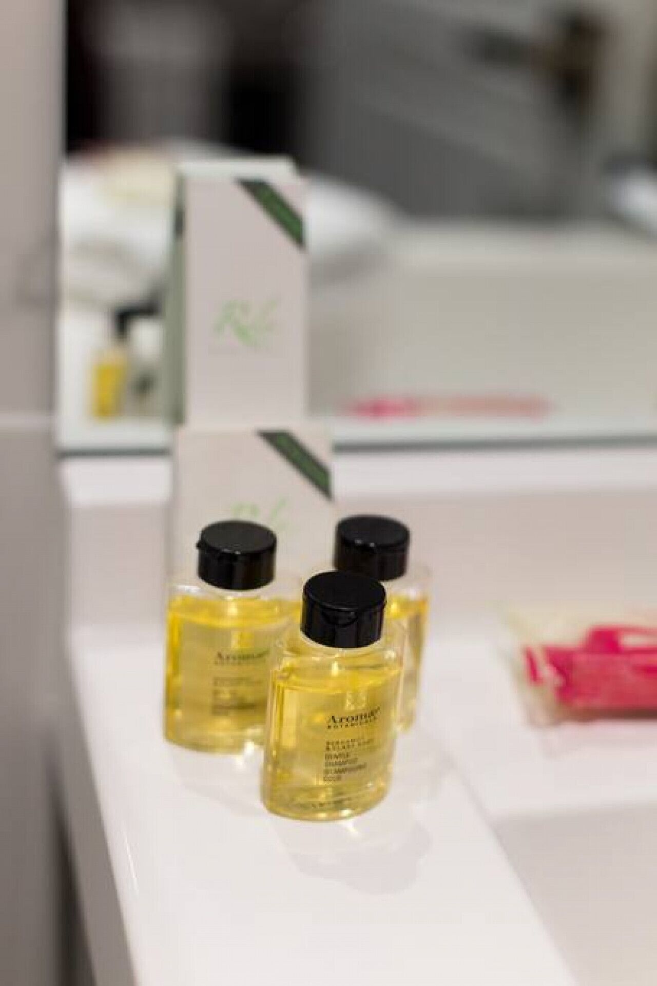 Three small bottles of perfume on a white surface.