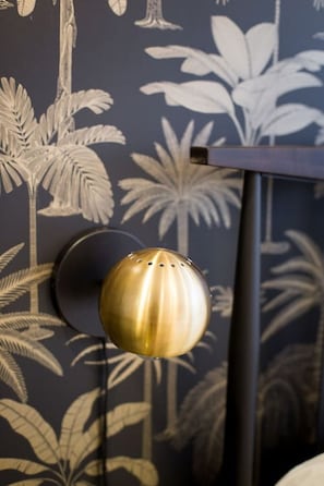 A wall-mounted light fixture with a spherical design and a metallic finish.