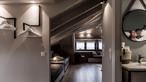 A bedroom with a lofted sleeping area, a desk, and a bathroom with a mirror and sink. - Casa Della Vita (Hersonissos)