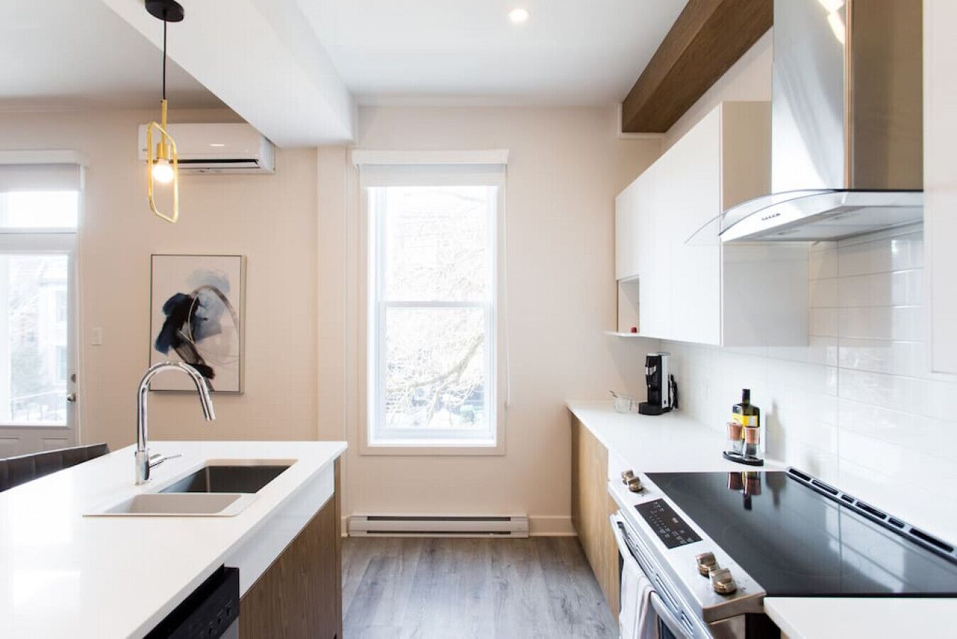 Una cucina moderna con forno a incasso, piano cottura e finestra che lascia entrare luce naturale.