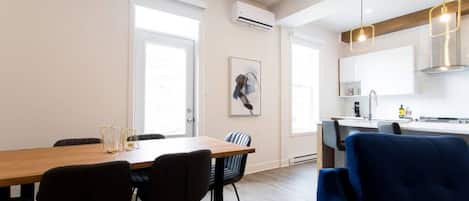 A modern apartment with a dining area, kitchen, and living space.